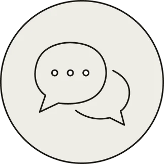 Circular icon with two overlapping speech bubbles, one containing three dots, on a light gray background.