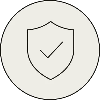 Black shield outline with a check mark inside on a light gray circular background.